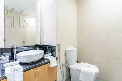 a bathroom with a sink and a toilet and a mirror at Spacious Modern 1BR in Business Bay in Dubai