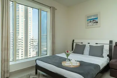 a bedroom with a bed with a view of a city at StoneTree - Lake View - Family-Friendly Location in Dubai