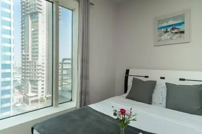 a bedroom with a bed and a large window at StoneTree - Lake View - Family-Friendly Location in Dubai