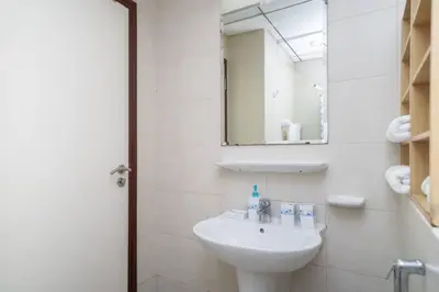 a white bathroom with a sink and a mirror at StoneTree - Lake View - Family-Friendly Location in Dubai