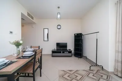 a living room with a dining table and a tv at StoneTree - Lake View - Family-Friendly Location in Dubai