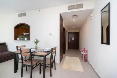a dining room and living room with a table and chairs at StoneTree - Lake View - Family-Friendly Location in Dubai