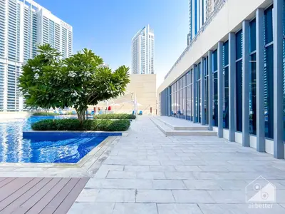 a walkway in the middle of a building with a tree at Luxurious Creek Harbour Apt with Balcony & View in Dubai