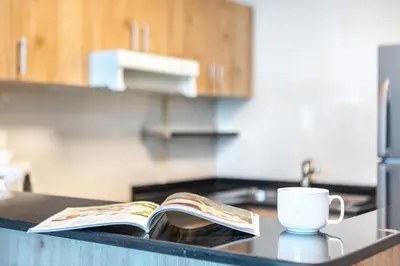a kitchen counter with a book and a cup of coffee at Cozy Heaven with full Marina View in Dubai