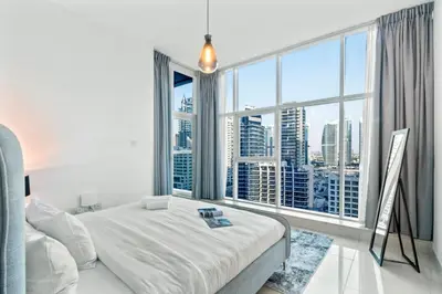 a bedroom with a bed and a large window at Cozy Heaven with full Marina View in Dubai
