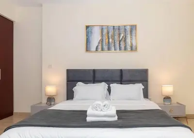 a bedroom with a bed with two towels on it at StoneTree - Studio Apartment Near The Beach in Dubai