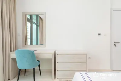 a bedroom with a blue chair and a desk at Dream Inn - Seven Palm - Free Beach Access in Dubai