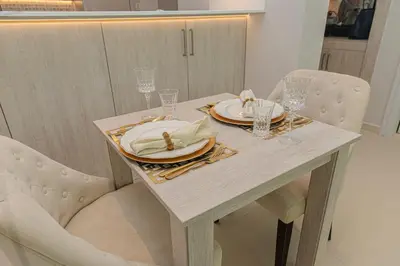 a dining table with two plates and glasses on it at Dream Inn - Seven Palm - Free Beach Access in Dubai