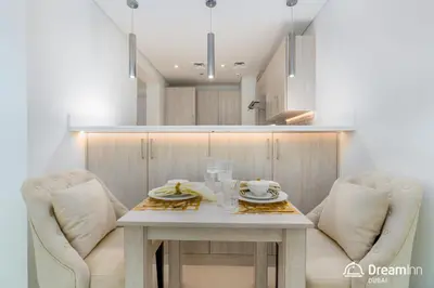 a kitchen with two chairs and a table with two cups at Dream Inn - Seven Palm - Free Beach Access in Dubai