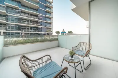 a balcony with two chairs and a table at StoneTree - Furnished Studio in Golf Promenade 3A in Dubai