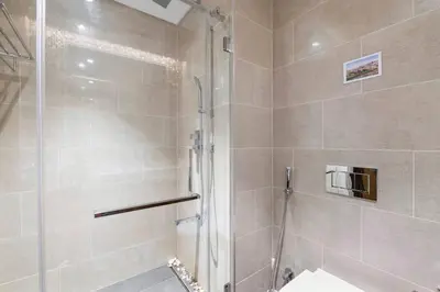 a shower with a glass door in a bathroom at StoneTree - Cozy 1 BR in Sobha Hartland Greens 1 in Dubai