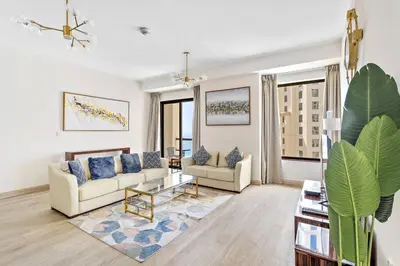 a living room with two couches and a table at StoneTree - Near Beach - Furnished 1BR with Partial Sea View in Dubai