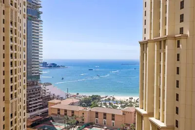 a view of the ocean from between two buildings at StoneTree - Near Beach - Furnished 1BR with Partial Sea View in Dubai
