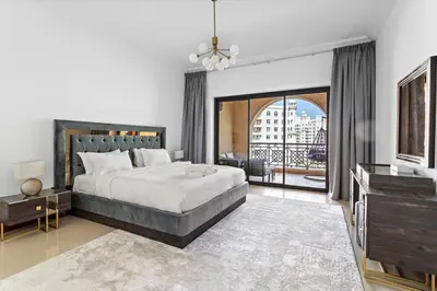 a bedroom with a large bed and a balcony at StoneTree - 2 BR apartment in Golden Mile 6 Near Nakheel Mall in Dubai