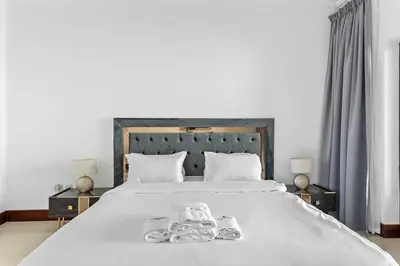 a large white bed with two towels on it at StoneTree - 2 BR apartment in Golden Mile 6 Near Nakheel Mall in Dubai