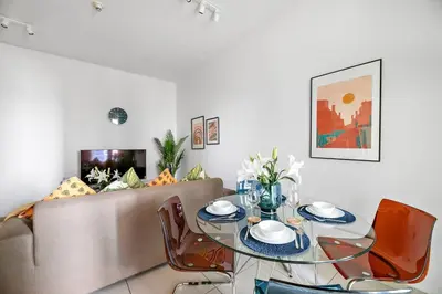 a dining room with a couch and a table and chairs at StoneTree - Furnished 1 BR Apartment Near to Tram in Dubai