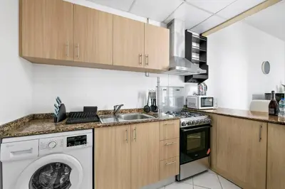 a kitchen with a washing machine and a sink at StoneTree - Furnished 1 BR Apartment Near to Tram in Dubai