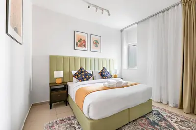 a bedroom with a large bed and a window at StoneTree - Furnished 1 BR Apartment Near to Tram in Dubai