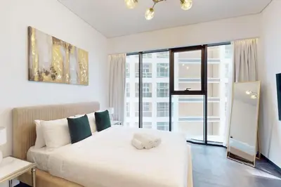 a bedroom with a white bed with a large window at O Ten, Al Jaddaf - Neat Studio in Dubai