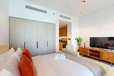 a living room with a large white bed and a television at 15 Northside Tower 1 - Elegant Studio in Dubai