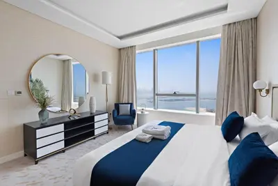 a bedroom with a large bed and a large window at StoneTree - Spacious 1 BR with Stunning Sea View in Palm Jumeirah in Dubai