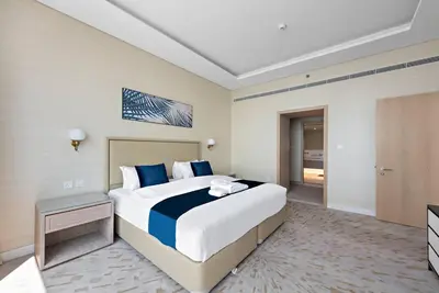 a hotel room with a large bed and a television at StoneTree - Spacious 1 BR with Stunning Sea View in Palm Jumeirah in Dubai