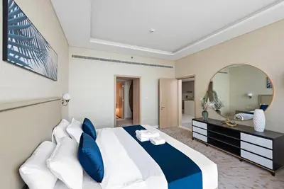 a bedroom with a large bed and a mirror at StoneTree - Spacious 1 BR with Stunning Sea View in Palm Jumeirah in Dubai