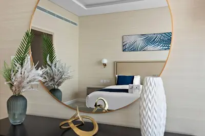 a bedroom with a bed and a large mirror at StoneTree - Spacious 1 BR with Stunning Sea View in Palm Jumeirah in Dubai