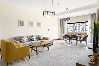 a living room with a couch and chairs and a table at StoneTree - Luxurious 2 BR Apartment in Palm Jumeirah in Dubai
