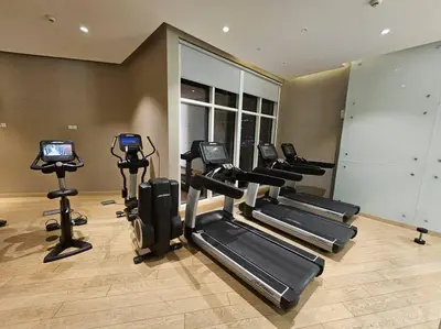 a gym with several tread machines in a room at Luxury Business Bay Studio with breathtaking views. in Dubai