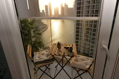 a table and chairs on a balcony with a view of the water at Luxury Business Bay Studio with breathtaking views. in Dubai