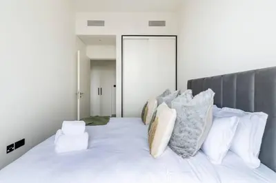 a bedroom with a white bed with pillows on it at 2bedroom apartment Dubai Hills in Dubai