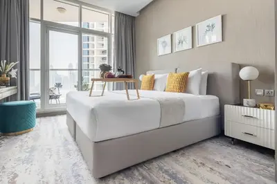 a bedroom with a white bed with a table on it at Frank Porter - Damac Prive B in Dubai