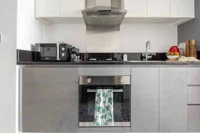 a kitchen with a stove and a microwave at Frank Porter - Damac Prive B in Dubai