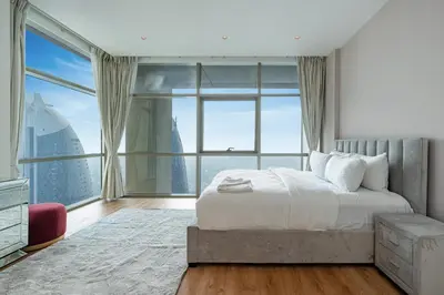 a bedroom with a bed and a large window at Upgraded 1BR on a high floor of Liberty House,DIFC - Allsopp&Allsopp in Dubai