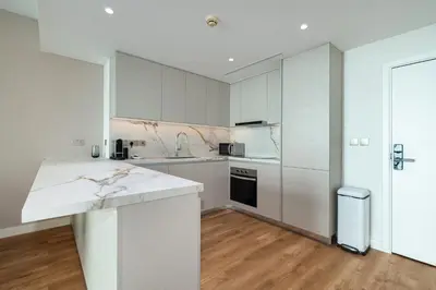 a kitchen with white cabinets and a white counter top at Upgraded 1BR on a high floor of Liberty House,DIFC - Allsopp&Allsopp in Dubai