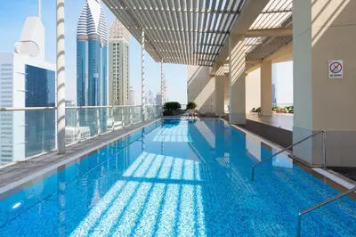a swimming pool on the roof of a building with tall buildings at Upgraded 1BR on a high floor of Liberty House,DIFC - Allsopp&Allsopp in Dubai