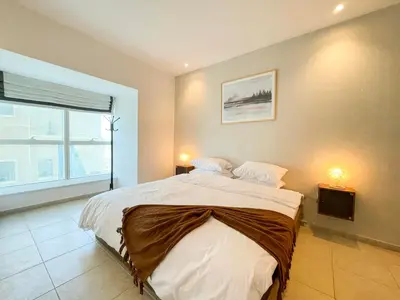 a bedroom with a large bed and a window at Deluxe 1 Bedroom Apartment - Elite Residence Dubai Marina - Sea View in Dubai