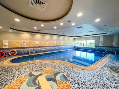 a pool in a building with a swimming pool at Deluxe 1 Bedroom Apartment - Elite Residence Dubai Marina - Sea View in Dubai