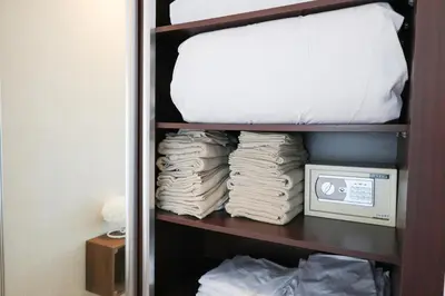 a shelf with a pile of towels and a mattress at Deluxe 1 Bedroom Apartment - Elite Residence Dubai Marina - Sea View in Dubai