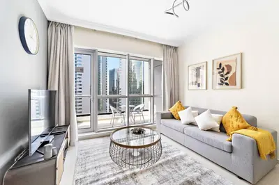 a living room with a couch and a tv at StoneTree - Near JBR Beach - Prime Location in Dubai