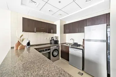a kitchen with a refrigerator and a dishwasher at StoneTree - Near JBR Beach - Prime Location in Dubai