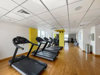 a row of treadmills in a gym with a row of treadms at StoneTree - Near JBR Beach - Prime Location in Dubai