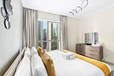a bedroom with a large bed and a window at StoneTree - Near JBR Beach - Prime Location in Dubai