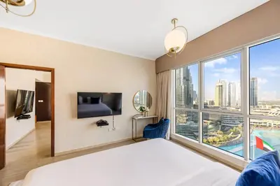 a bedroom with a bed and a large window at Durrani Homes - Grandiose 5BR Besides Dubai Mall with Burjkhalifa and Fountain view in Dubai