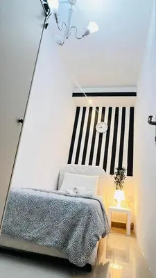 a bedroom with a bed and a black and white striped wall at Strips Partition Room Al barsha 1 Near MOE Metro in Dubai