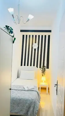 a small bedroom with a bed and a table at Strips Partition Room Al barsha 1 Near MOE Metro in Dubai