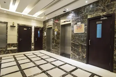 a bathroom with black doors and marble walls at Strips Partition Room Al barsha 1 Near MOE Metro in Dubai