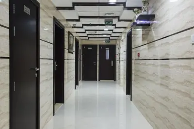 an empty hallway in a building with black doors at Strips Partition Room Al barsha 1 Near MOE Metro in Dubai
