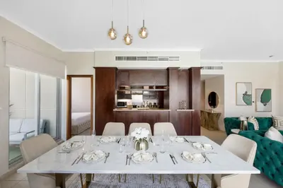 a dining room and living room with a table and chairs at Durrani Homes - Lavish 3BR Besides Burj Khalifa and Fountain view in Dubai